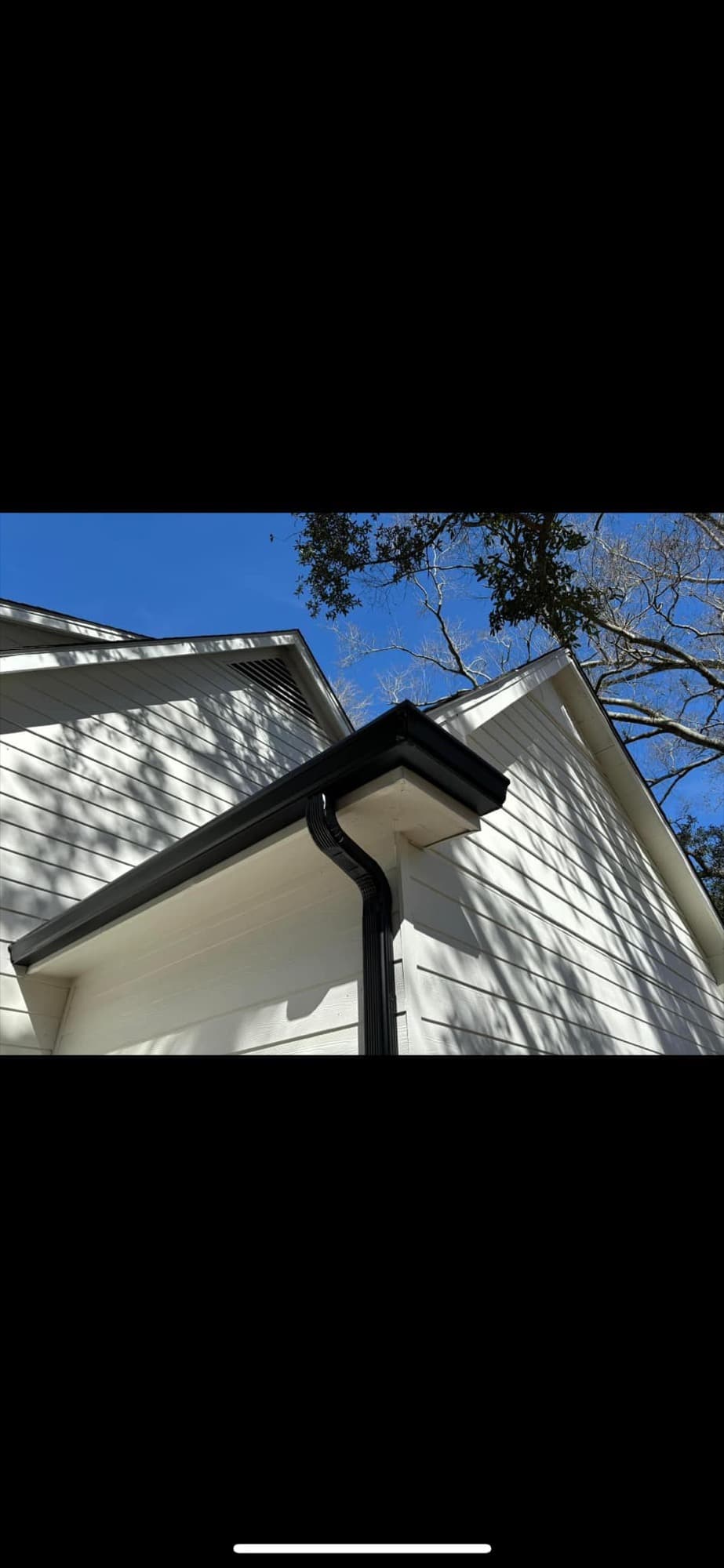Black aluminum gutters installed on white siding — Raceland, LA